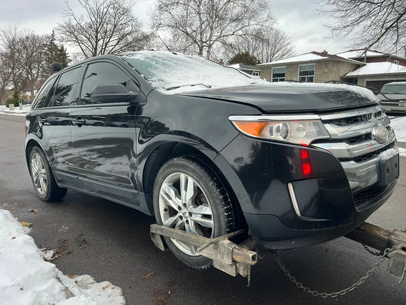 Oshawa scrap car pickup: vehicle secured to a tow truck for removal